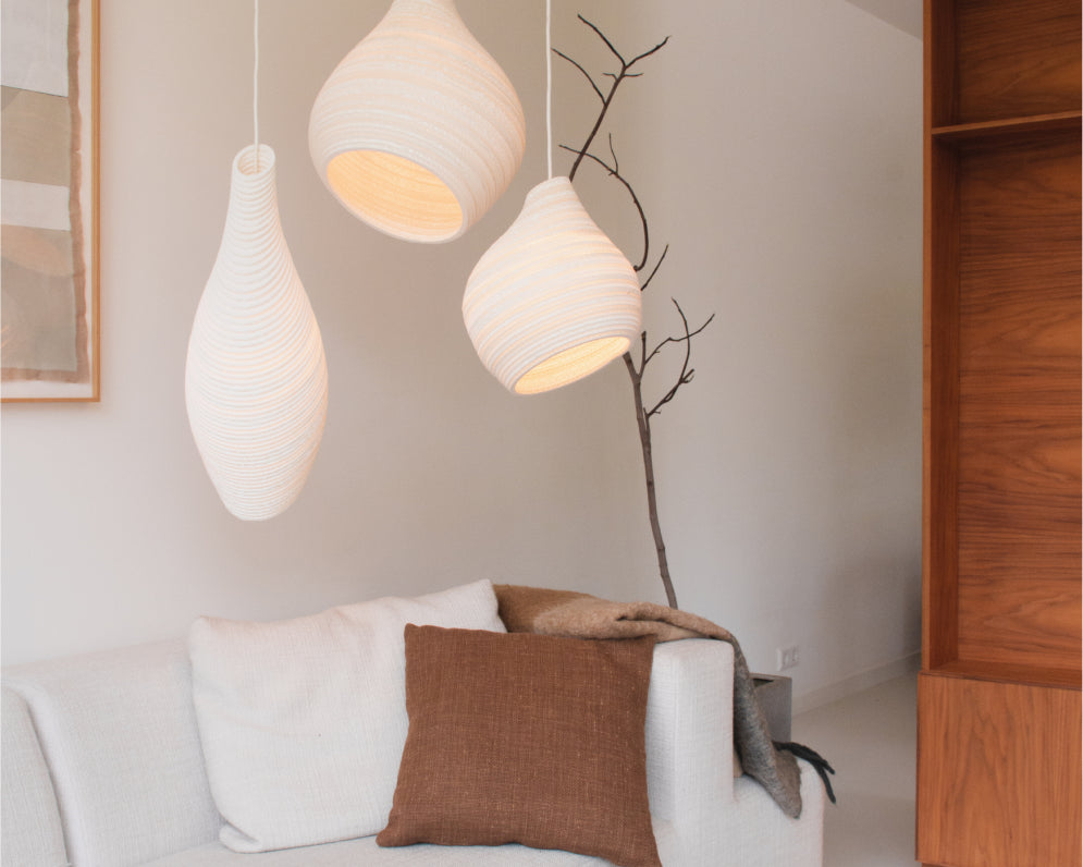 White cluster pendant lights above sofa